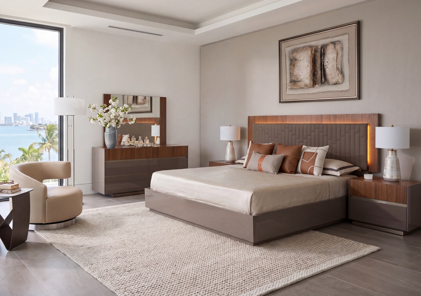 Bedroom with a walnut platform bed, matching nightstands and dresser, a swivel accent chair and bay views through the window wall.